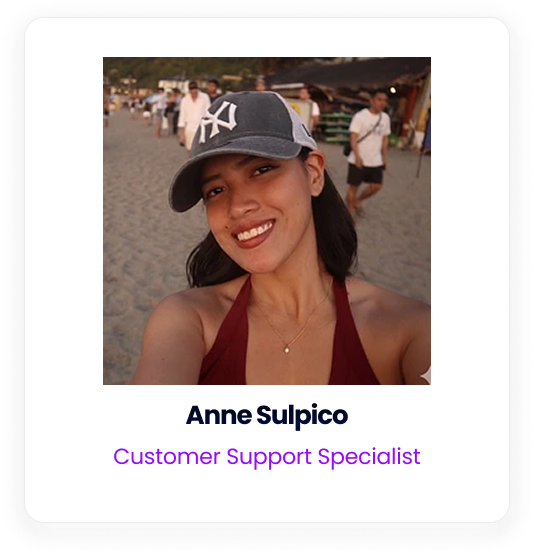Anne Sulpico wearing a baseball cap on a beach.