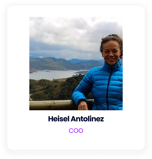 Heisel Antolinez, COO, smiling while standing outdoors in front of a lake and mountain landscape.