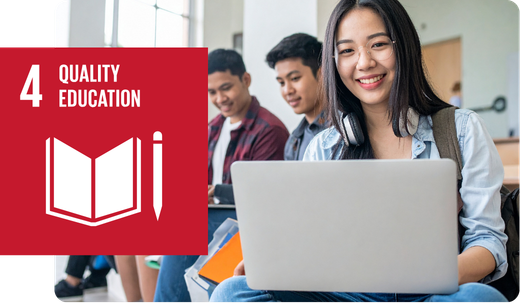 A student smiling while using a laptop in a classroom setting, next to the United Nations Sustainable Development Goal 4 icon for Quality Education.