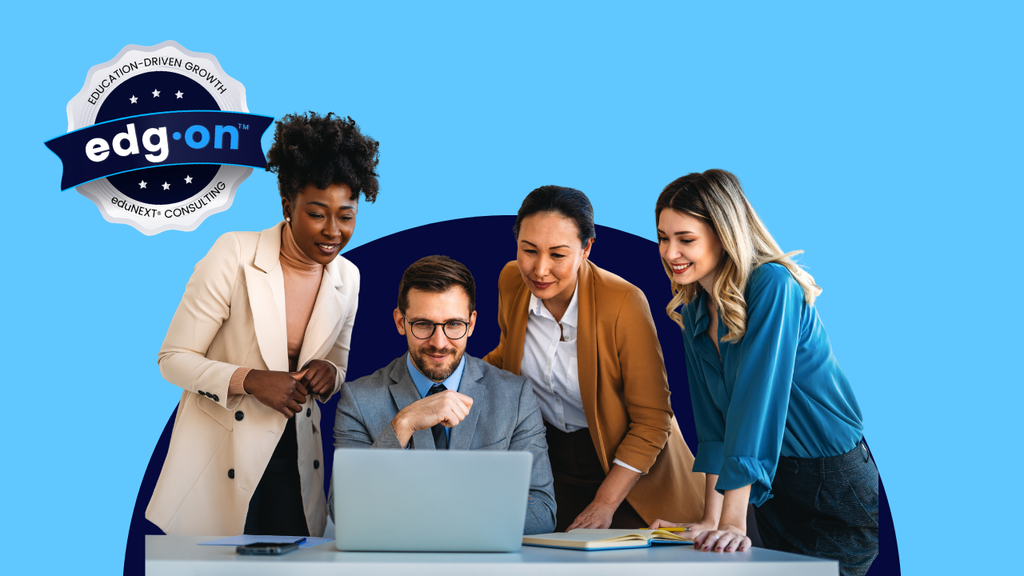 A diverse group of four professionals gathered around a laptop, looking at the screen together in a collaborative office setting.
